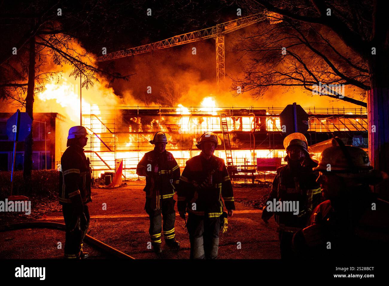 Firefighters extinguish a burning new school building in the Lohbrügge