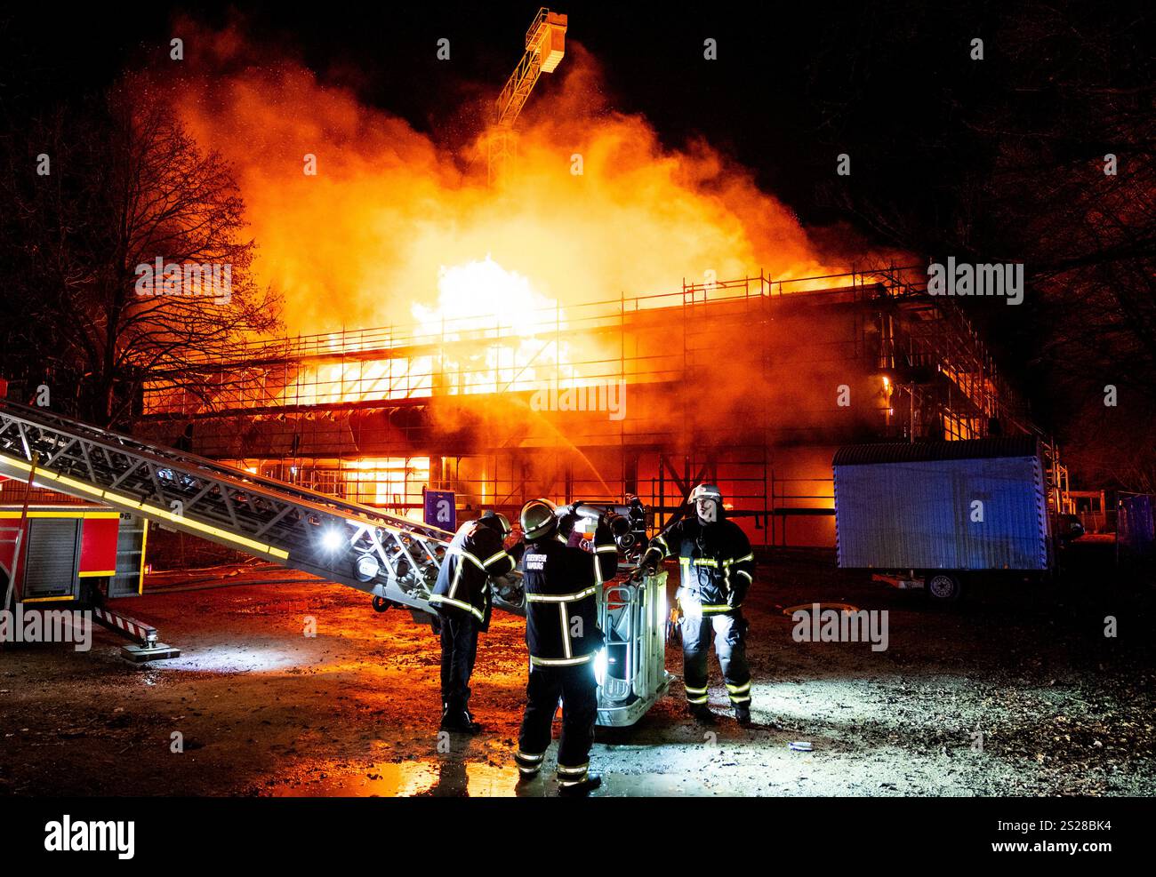 Firefighters extinguish a burning new school building in the Lohbrügge