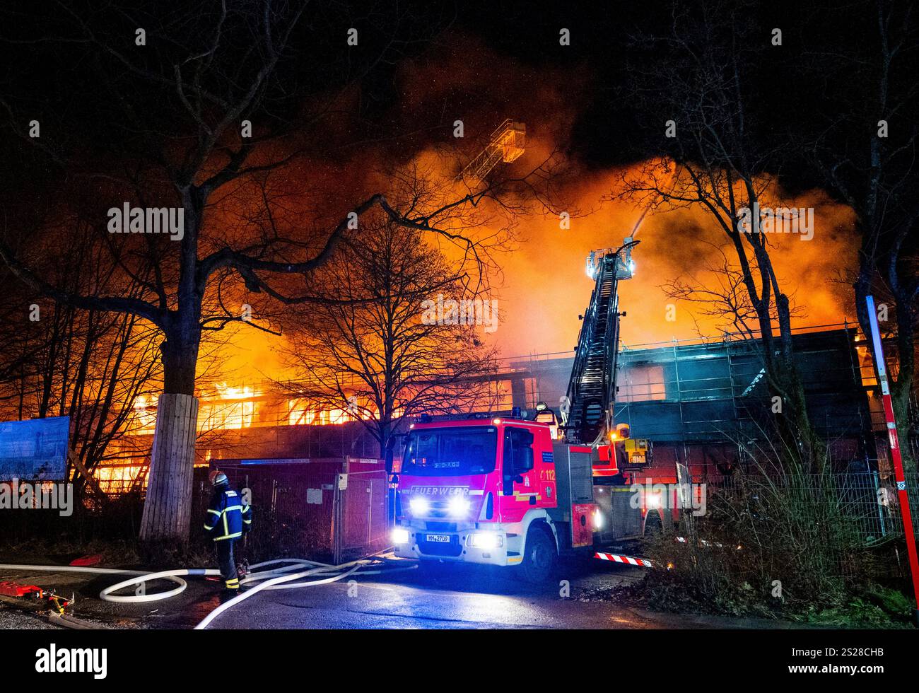 Firefighters extinguish a burning new school building in the Lohbrügge