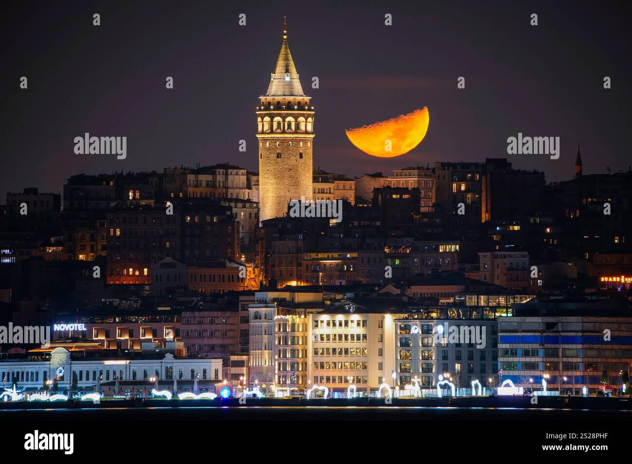 A half moon sets next to the Galata Tower in Istanbul, Tuesday, Jan. 7 ...