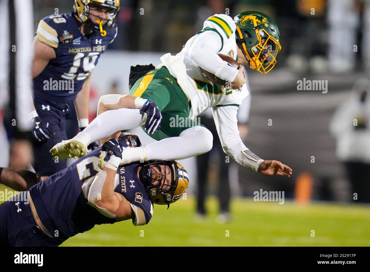 North Dakota State quarterback Cam Miller, top, is tackled by Montana