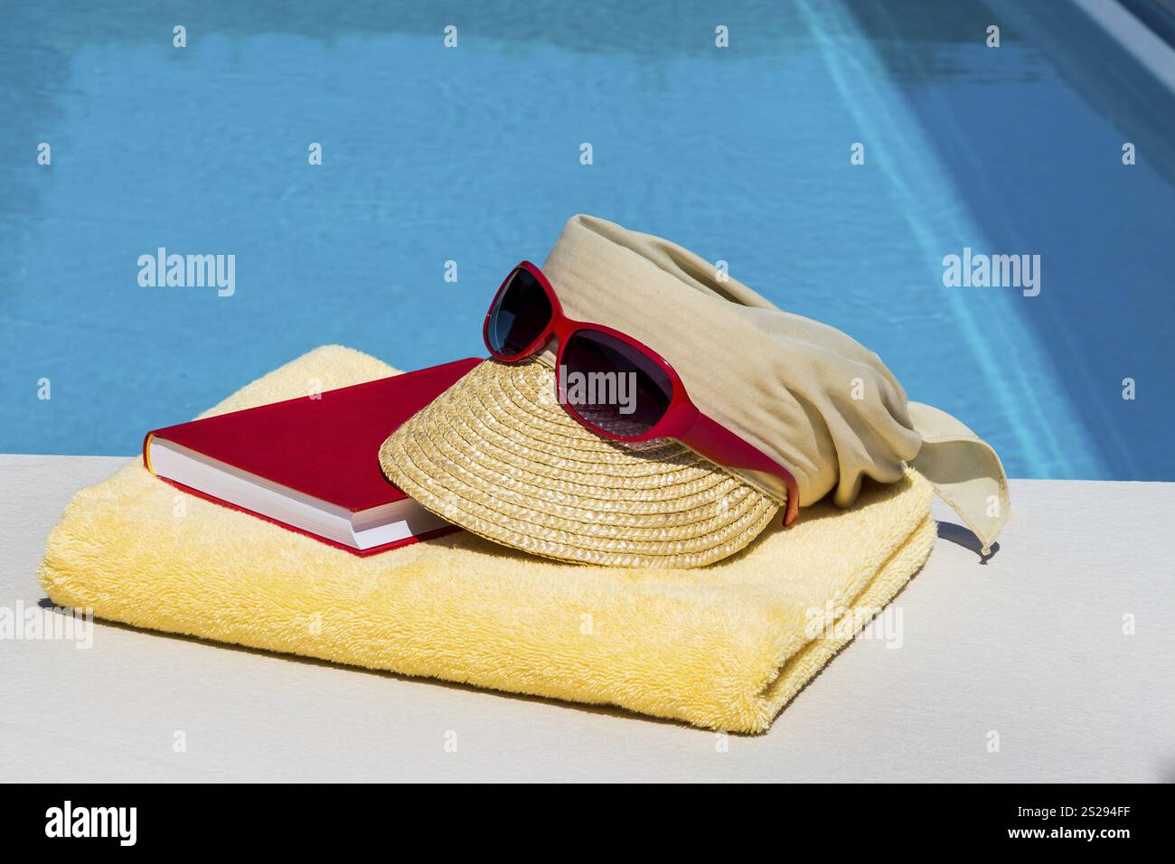 Utensils for a nice and relaxing holiday are next to a swimming pool. Relaxation on holiday. Austria Stock Photo