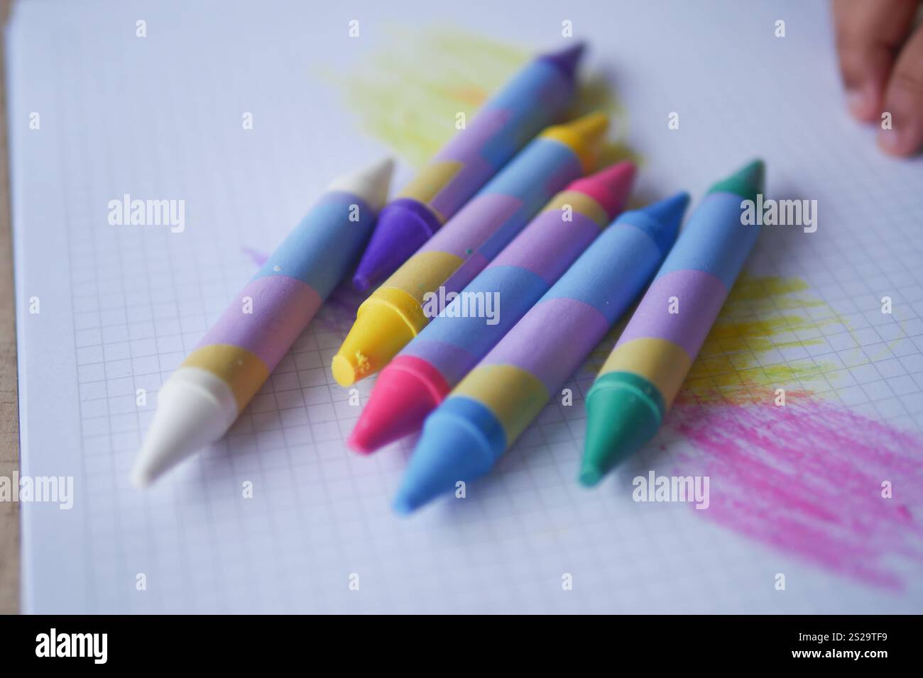 A Collection of Colorful Crayons on Graph Paper for Fun Creative Projects Stock Photo