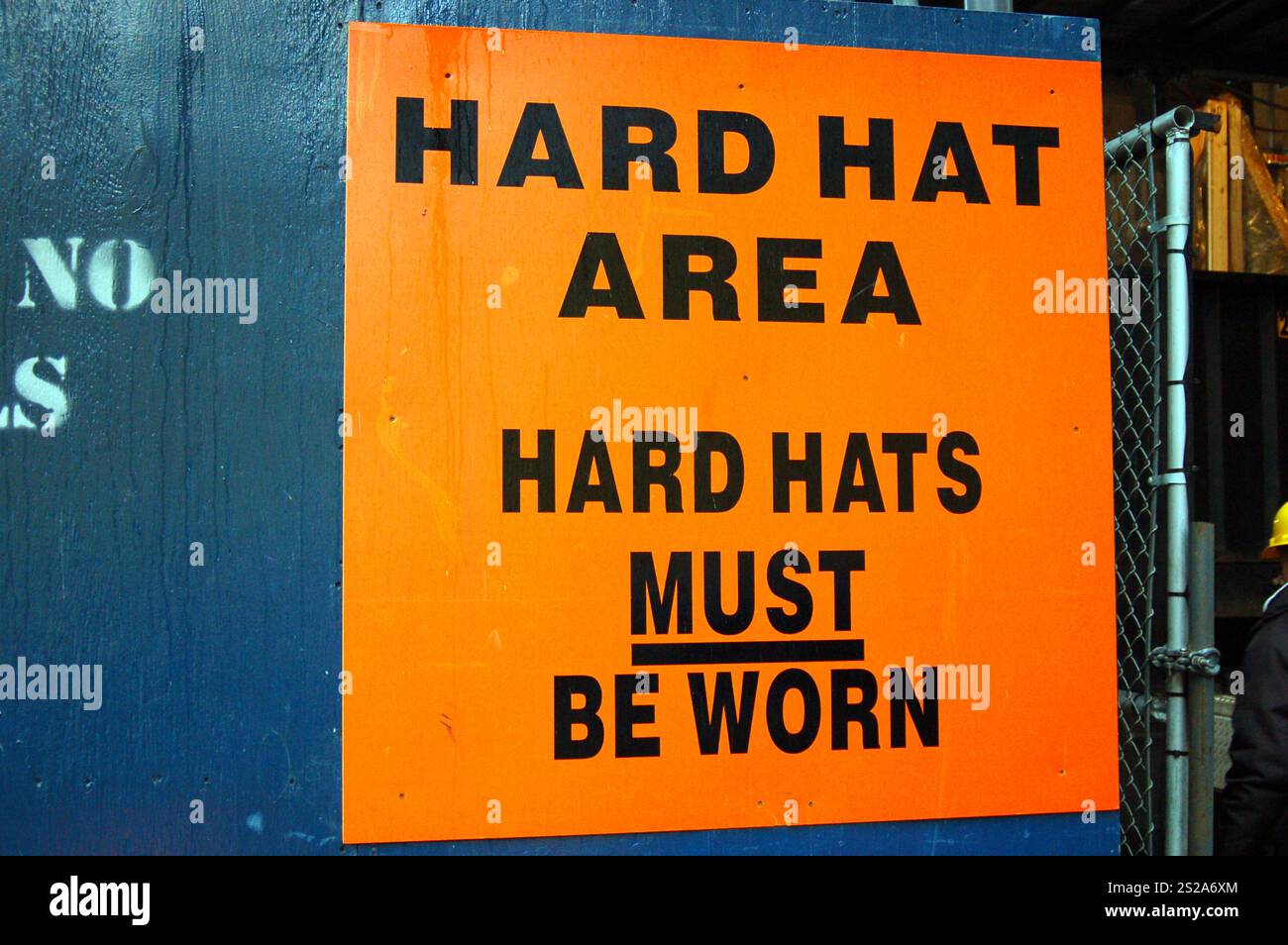 A sign outside of a construction site in New York City reminds all workers and visitors that hard hats must be worn at all times Stock Photo