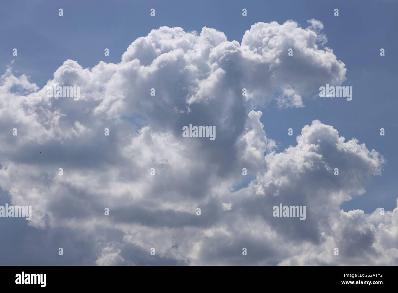 fluffy white gray clouds against deep blue sky Stock Photo