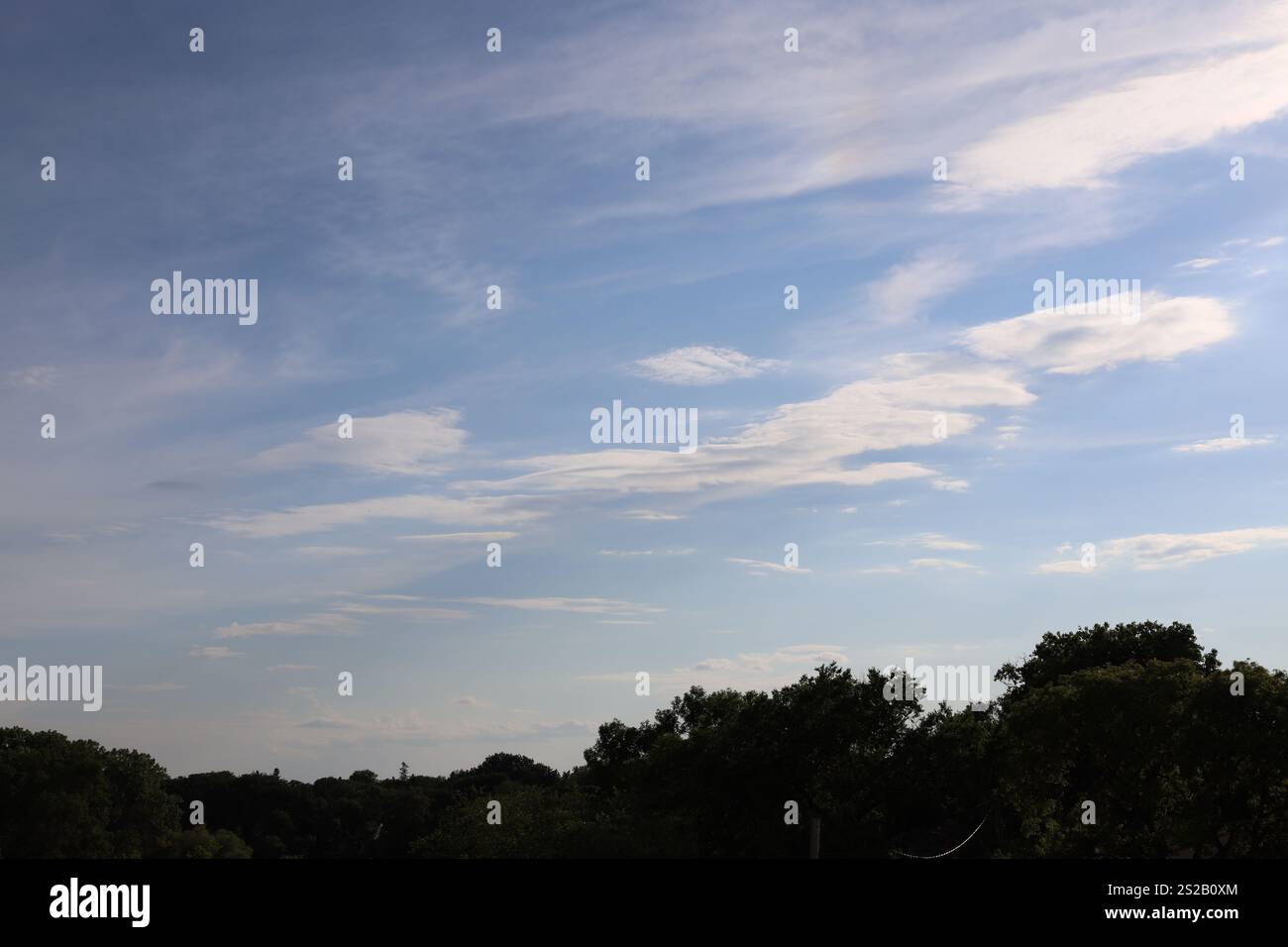 scattered white clouds in deep blue sky Stock Photo