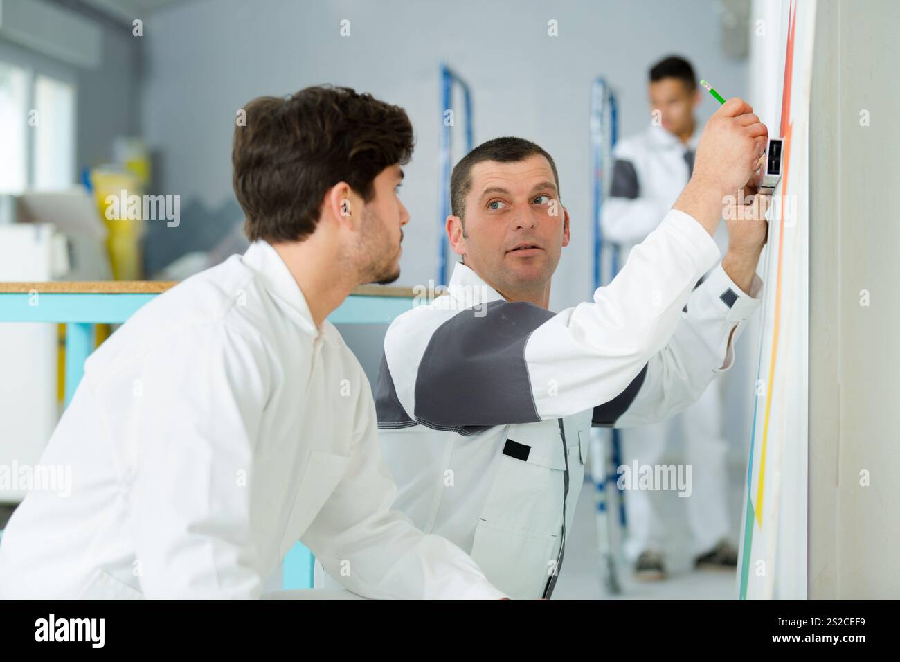 painter with apprentice and client Stock Photo