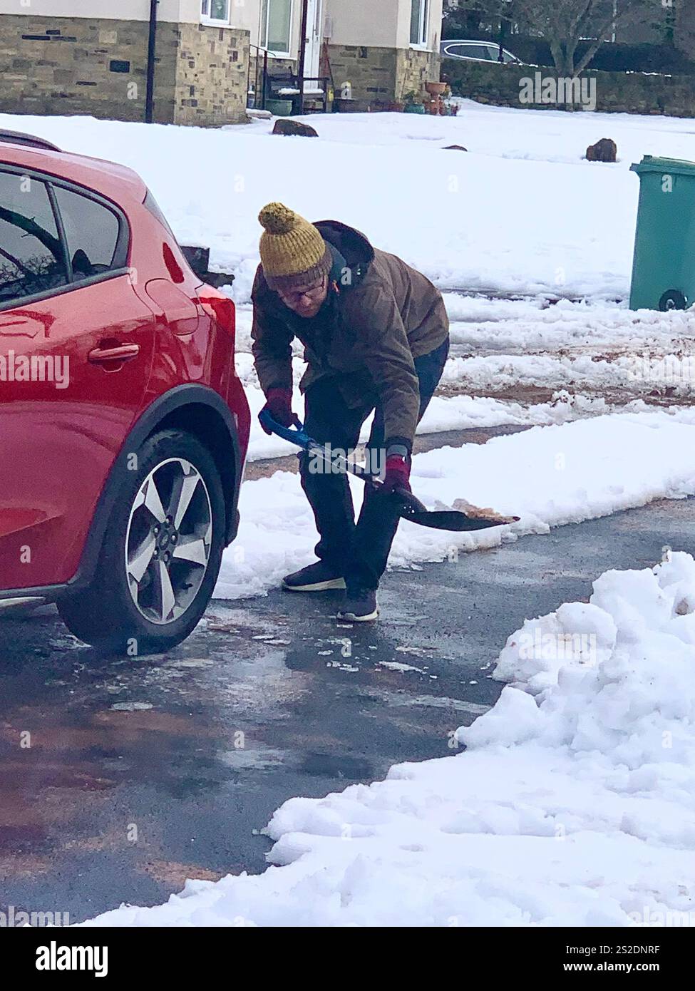 Guiseley North Yorkshire snow ice Weather Christmas clearing clear drive driveway place Town home live lived snowing storm Airport sludge spade man UK - Smartphone Captured Stock Image