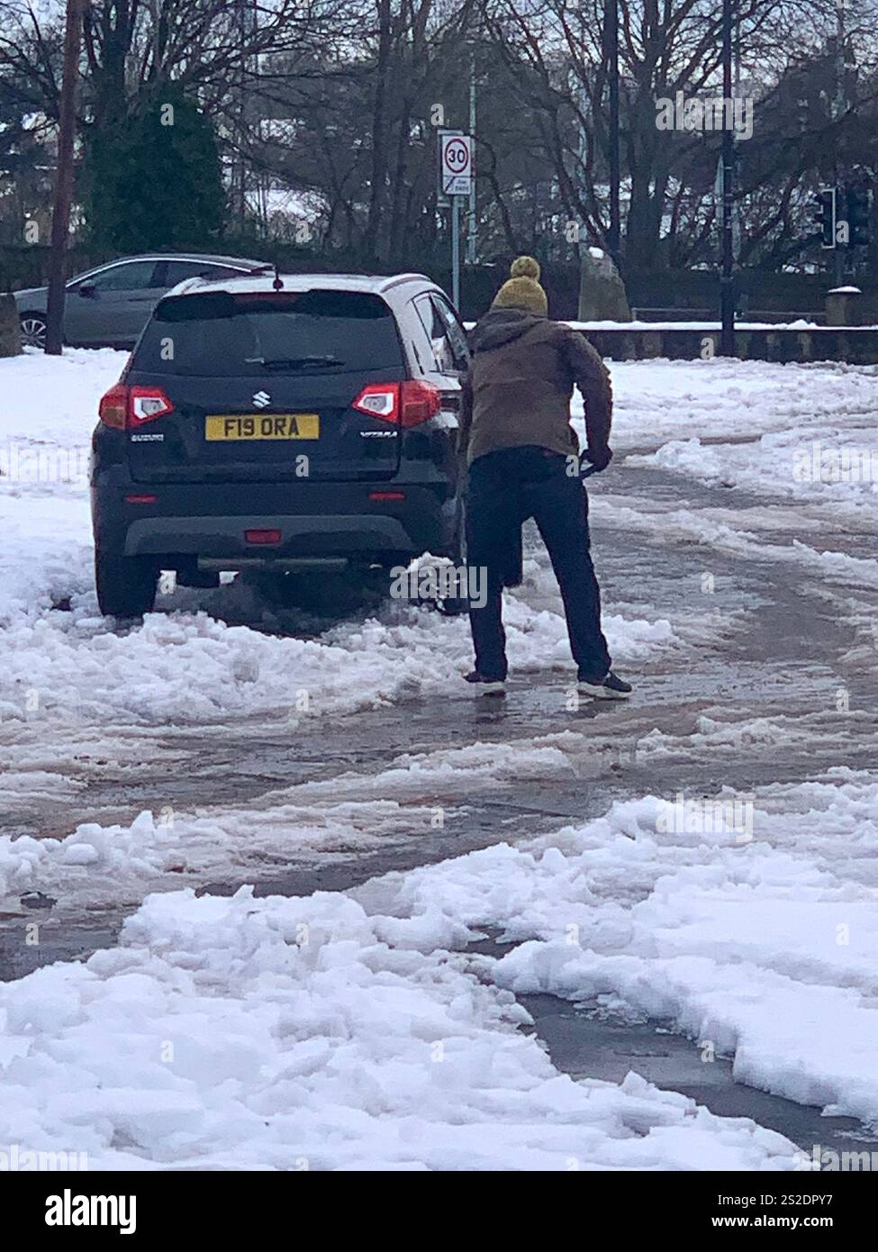 Guiseley North Yorkshire snow ice Weather Christmas clearing clear drive driveway place Town home live lived snowing storm Airport sludge spade man UK - Smartphone Captured Stock Image