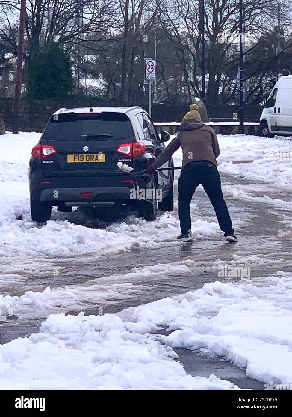 Guiseley North Yorkshire snow ice Weather Christmas clearing clear drive driveway place Town home live lived snowing storm Airport sludge spade man UK - Smartphone Captured Stock Image