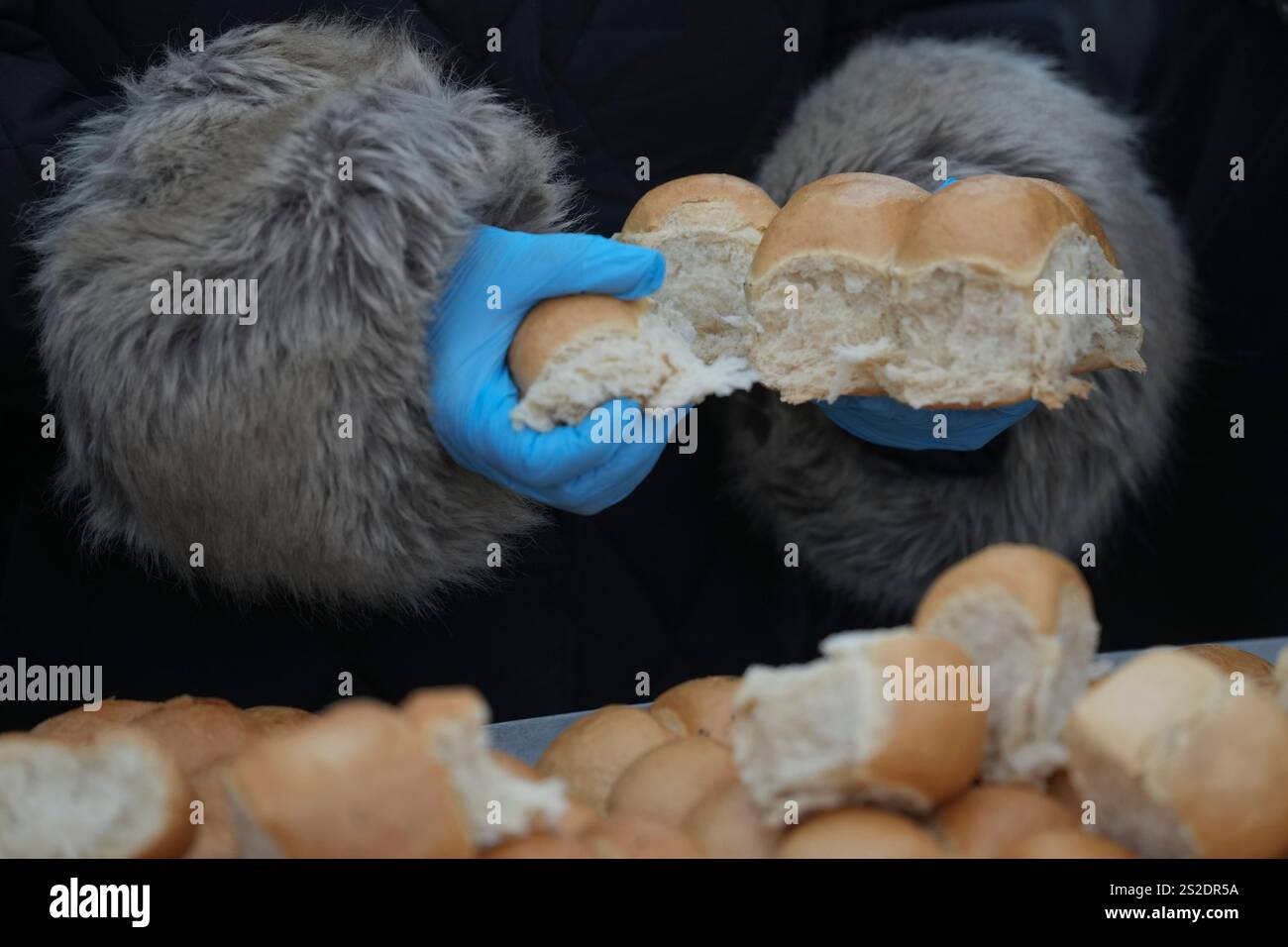 A baker breaks traditional Christmas bread to mark the Orthodox Christmas Day festivities in