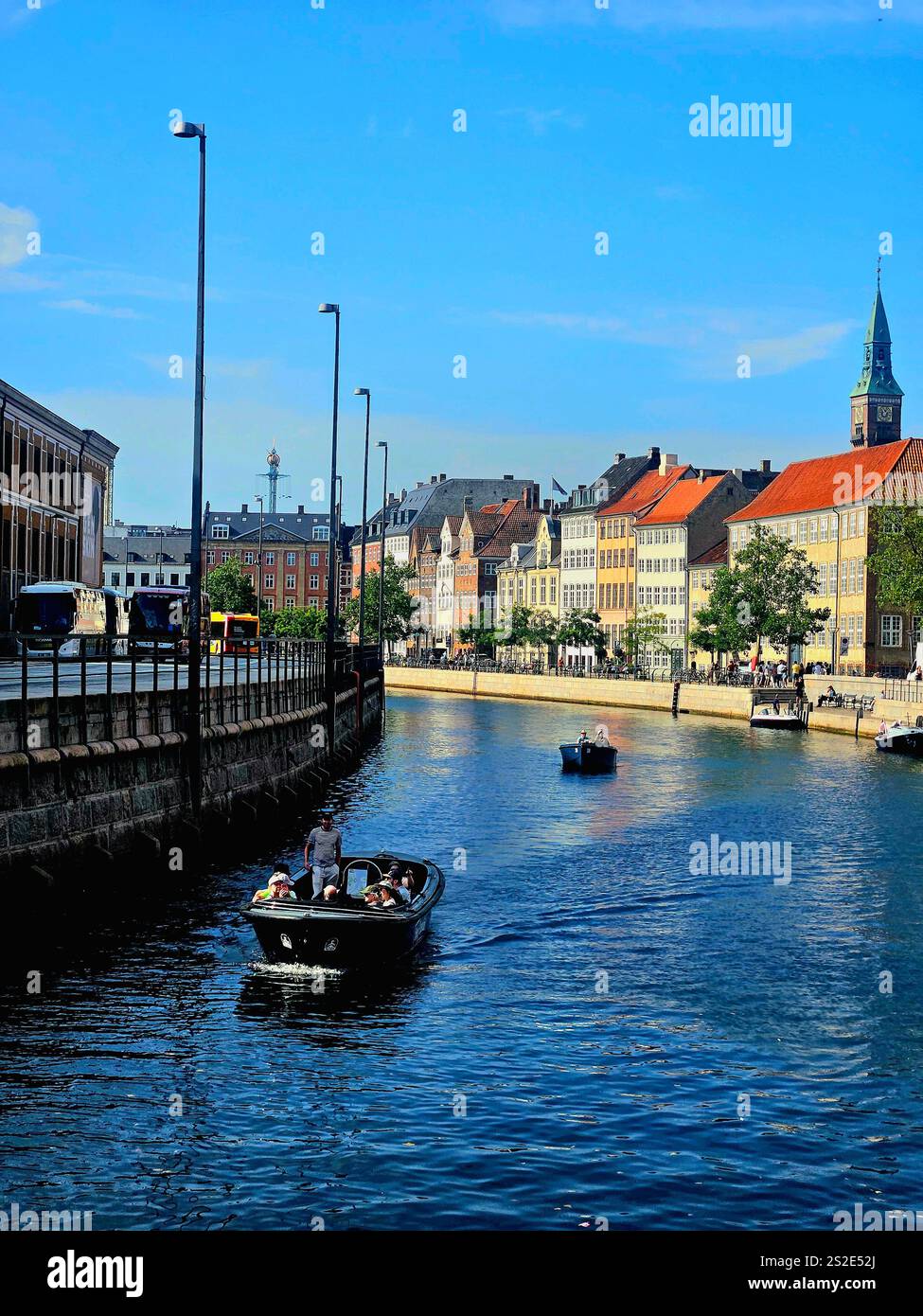 A view on the Nyhaven channel in Denmark with a Boat and buildings in summer with a blue sky - Smartphone Captured Stock Image