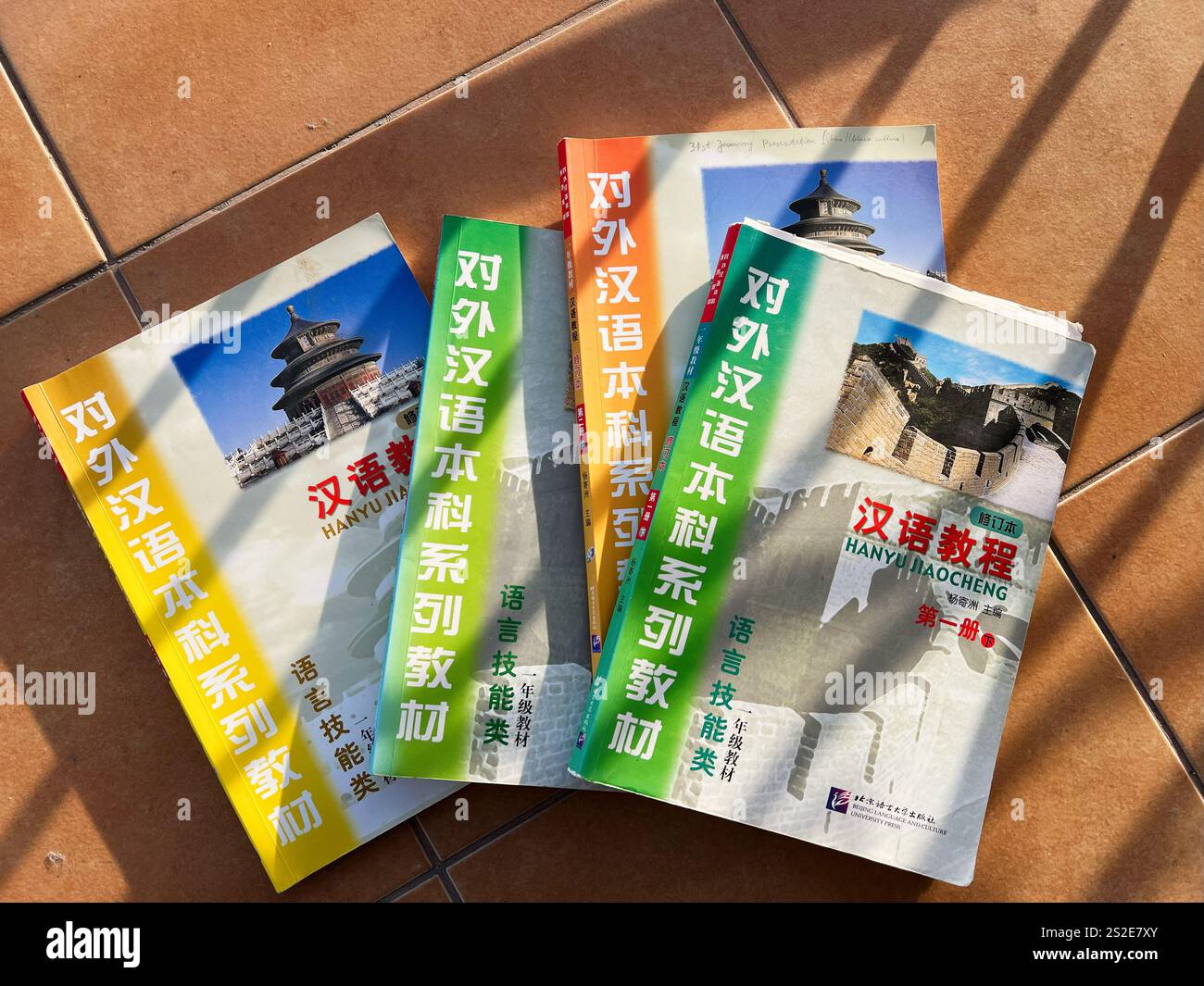 Kyiv, Ukraine - January 07, 2025: A collection of textbooks for learning foreign languages lies on a tiled floor, illuminated by sunlight, displaying Stock Photo