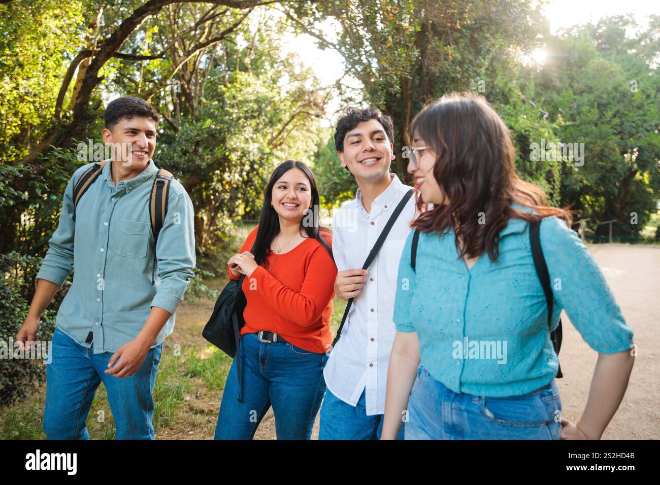 Happy university students walking and talking in the park Stock Photo