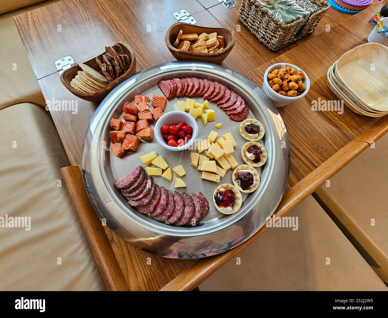 Cheese, sausage, and salmon on a platter with biscuits and red peppers - Smartphone Captured Stock Image