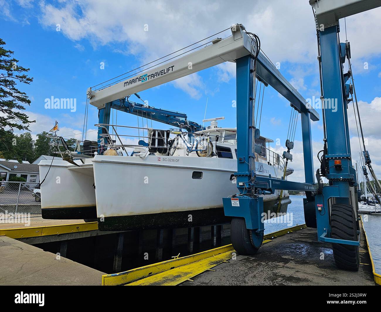 Power catamaran being hauled out by a travel lift. - Smartphone Captured Stock Image
