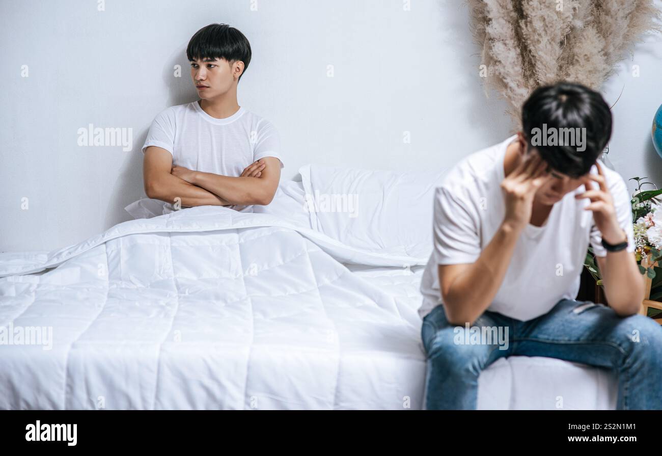Two young men were angry on the bed and the other sat at the edge of ...