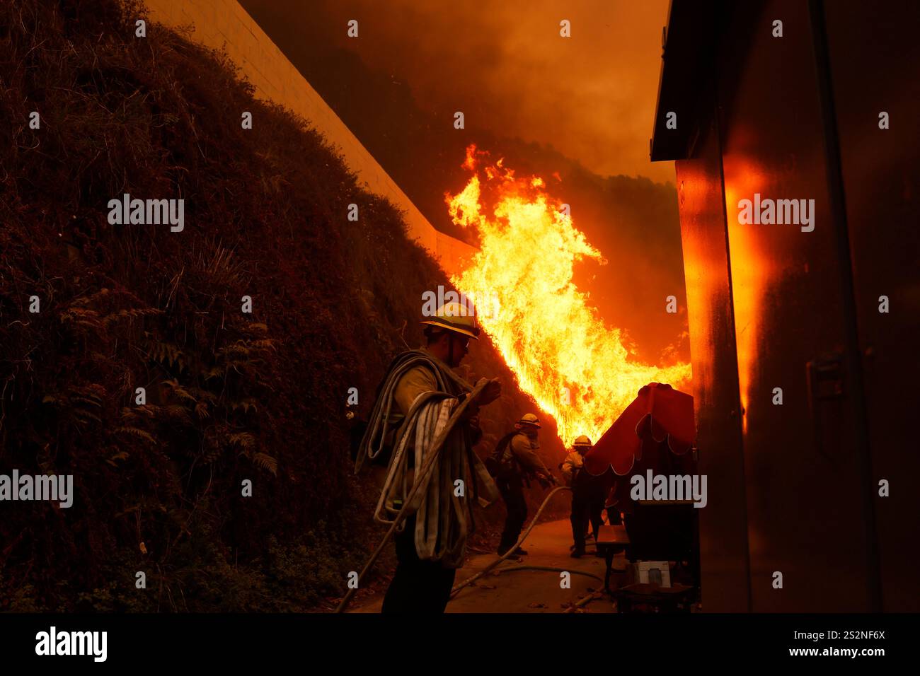 Firefighters protect structures from the advancing Palisades Fire in
