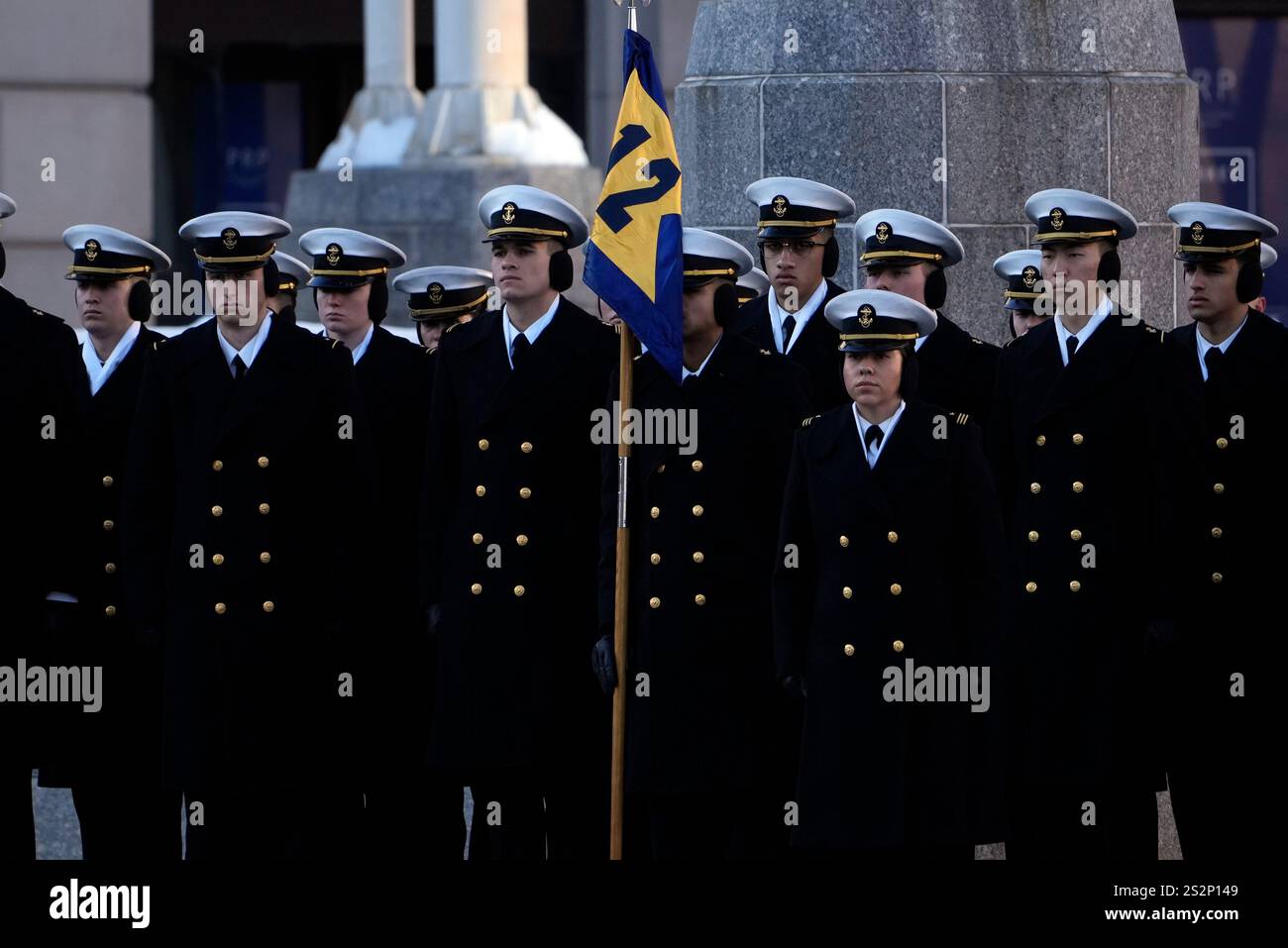 Midshipmen from the U.S. Naval Academy watch as the casket containing