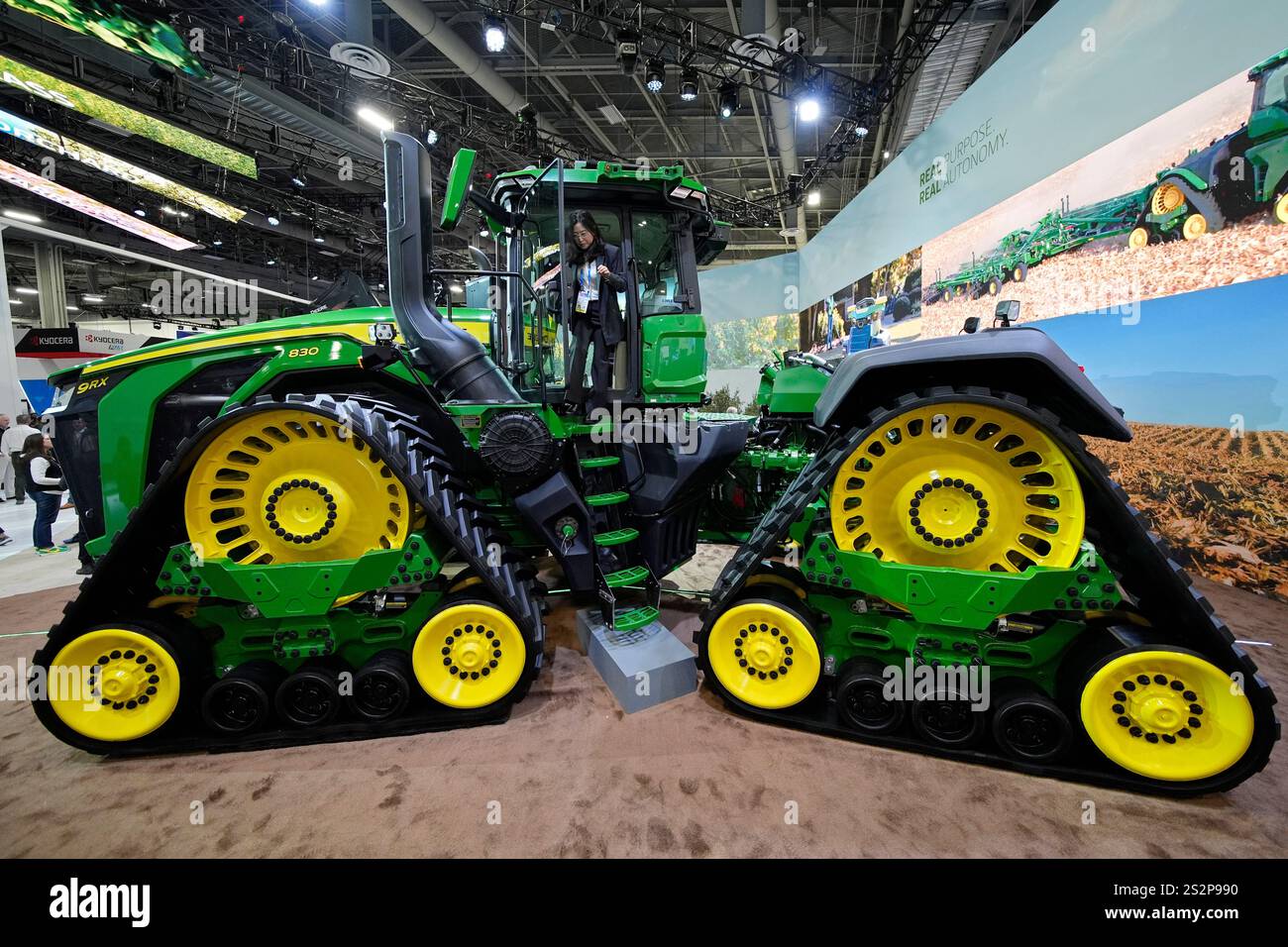 A convention goer exits a John Deere 9RX Tractor at the John Deere ...