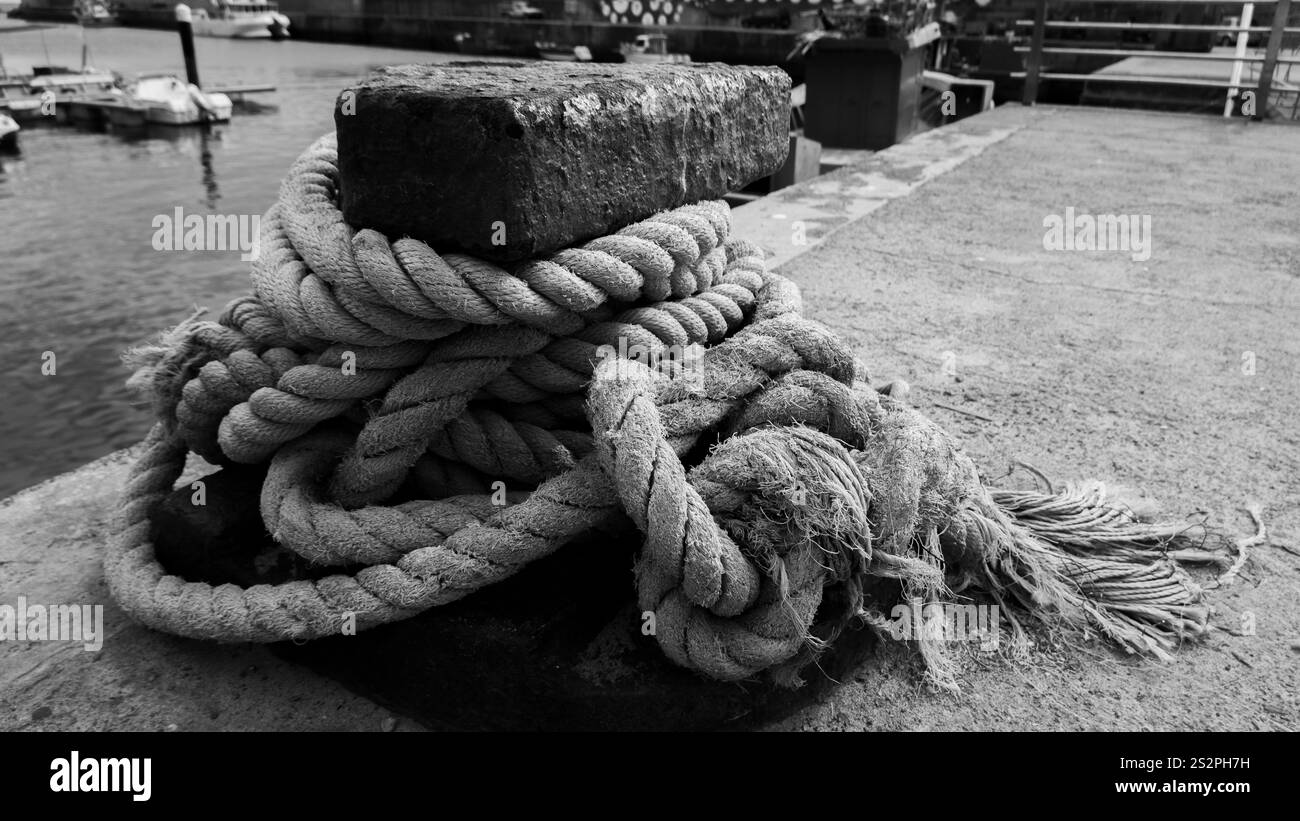 Black-and-white close-up of a thick, frayed rope tightly wrapped around ...