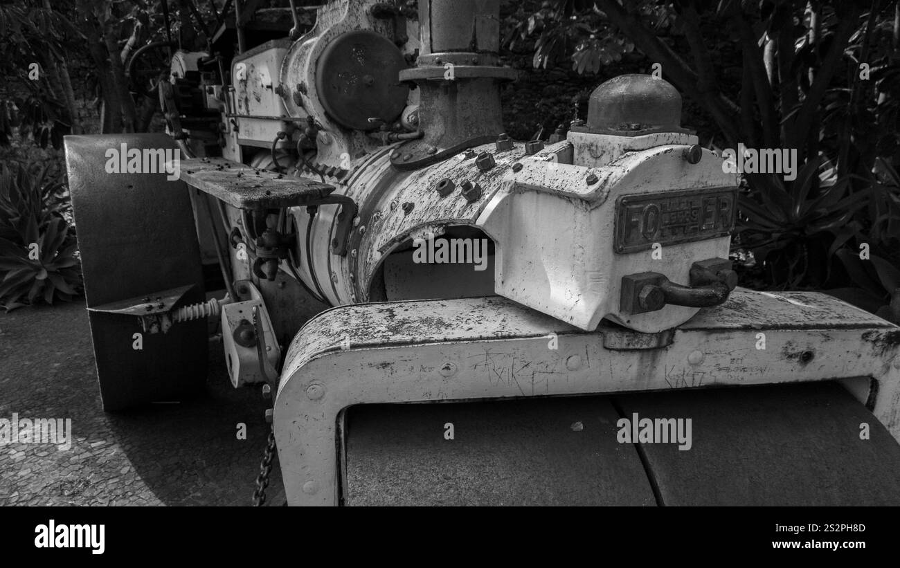 A black and white image of a vintage steamroller with visible wear and ...