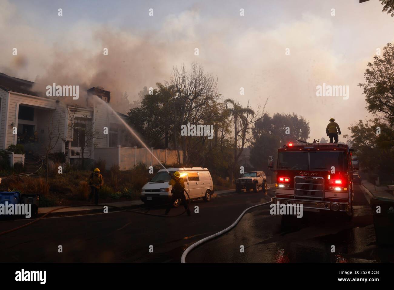 Fire crews work to prevent the Palisades Fire from burning a residence
