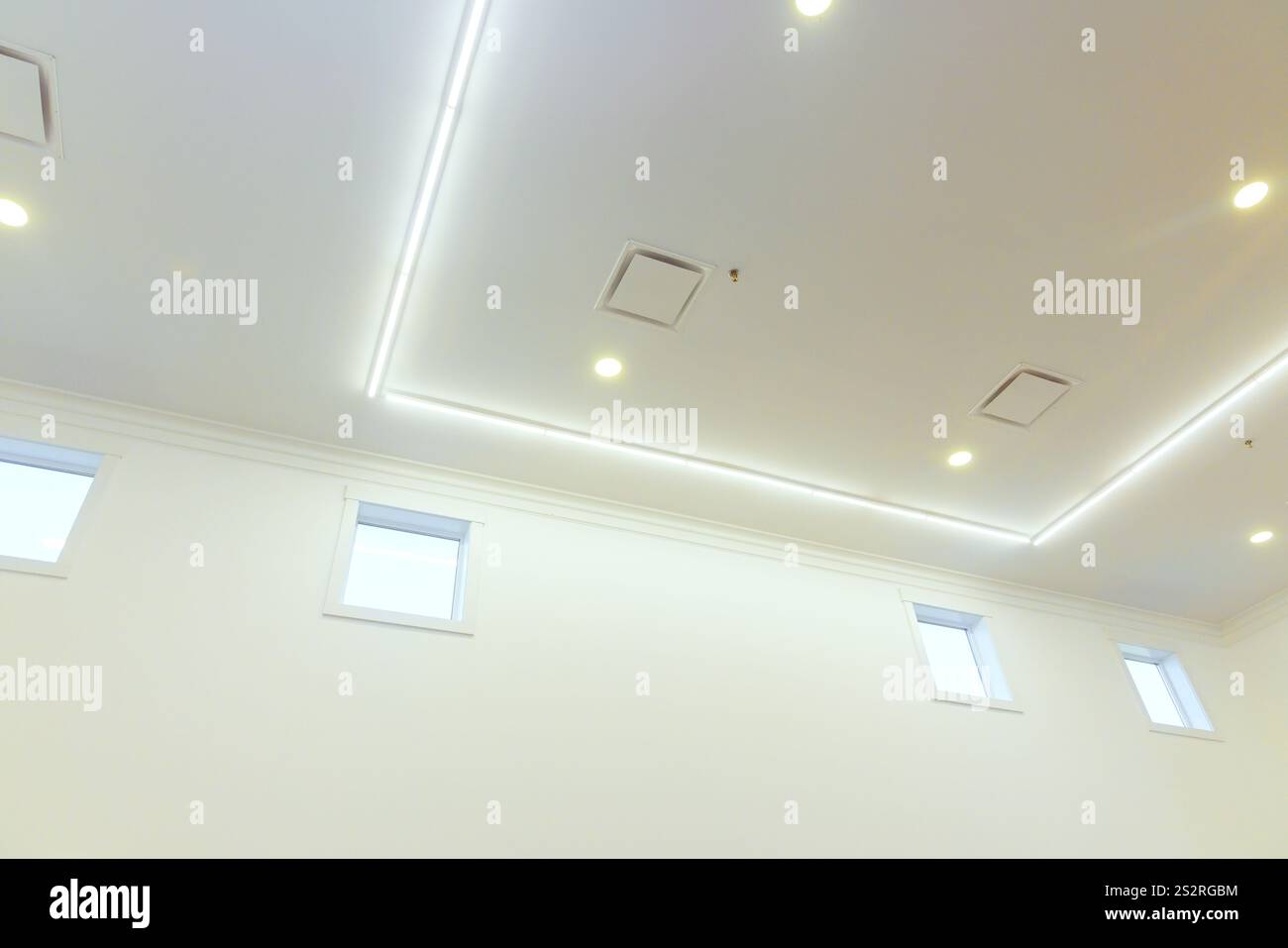 Bright ceiling lights illuminate spacious room, showcasing clean lines ...