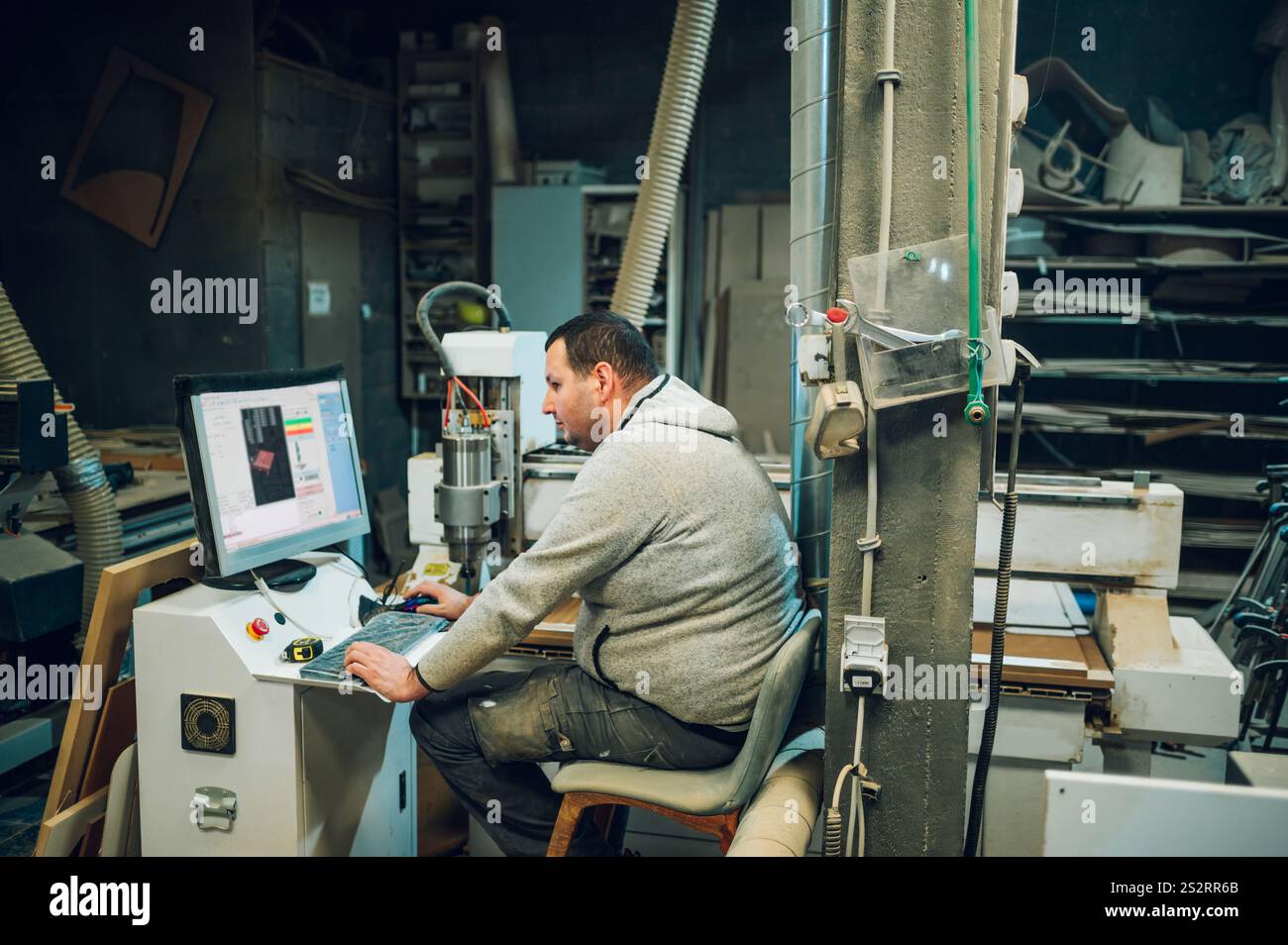 Experienced worker changing tool setup of CNC machine while working in ...