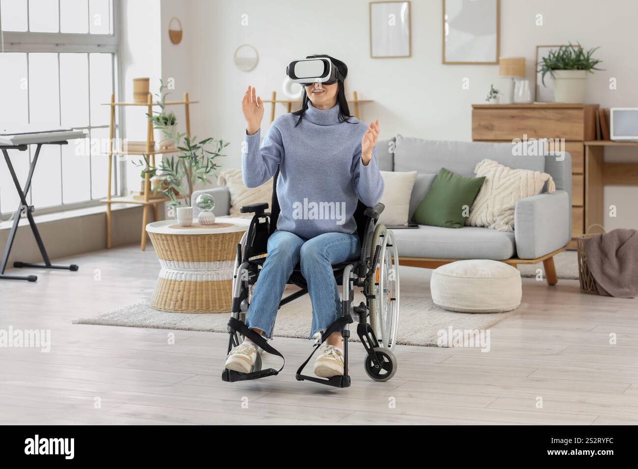 Beautiful young woman in wheelchair with VR glasses at home Stock Photo ...