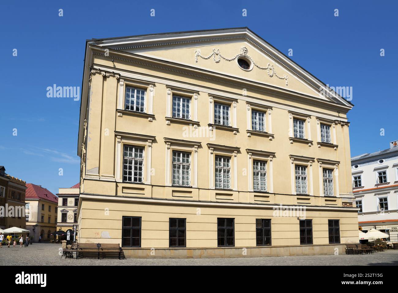 Yellow building with neoclassical facade and many windows under a sunny ...