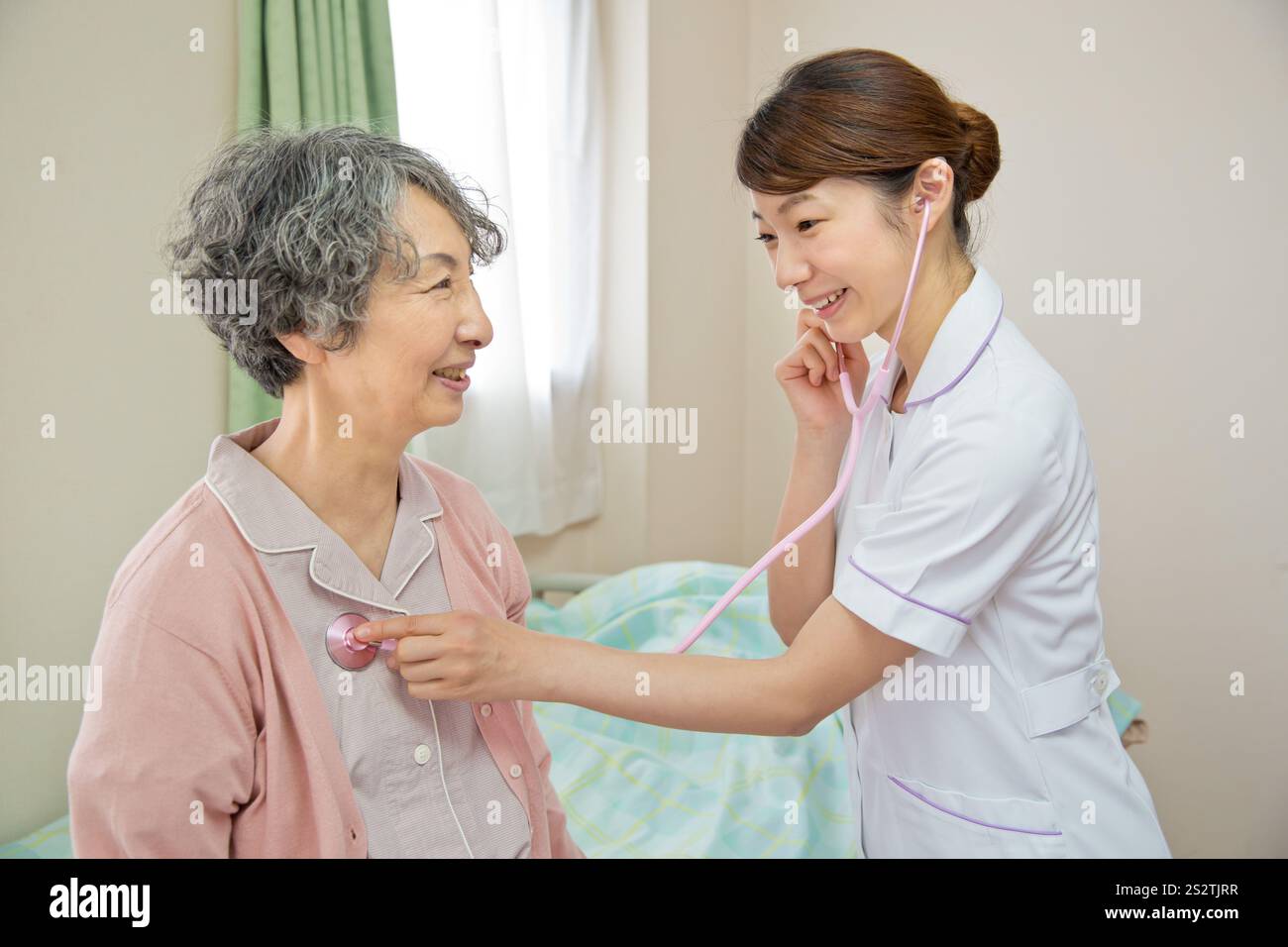 Nurse applying stethoscope to senior female patient Stock Photo - Alamy