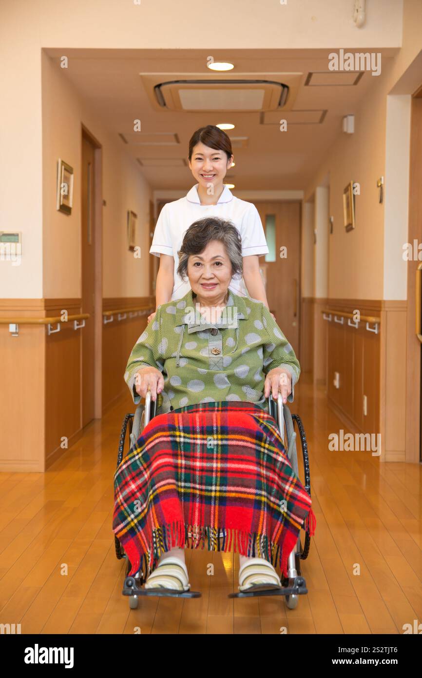 Nurse pushing a wheelchair for a senior female patient Stock Photo - Alamy