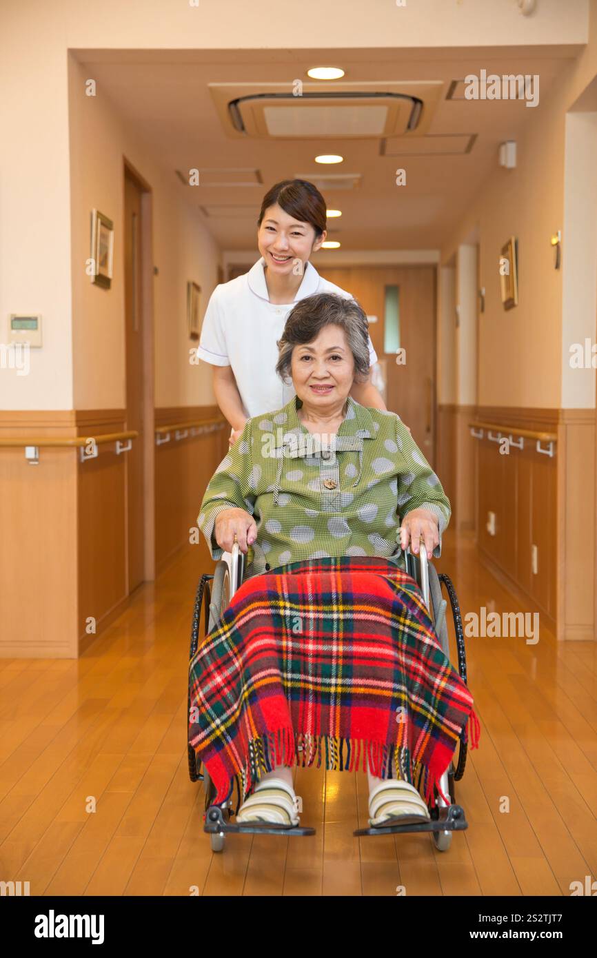 Nurse pushing a wheelchair for a senior female patient Stock Photo - Alamy