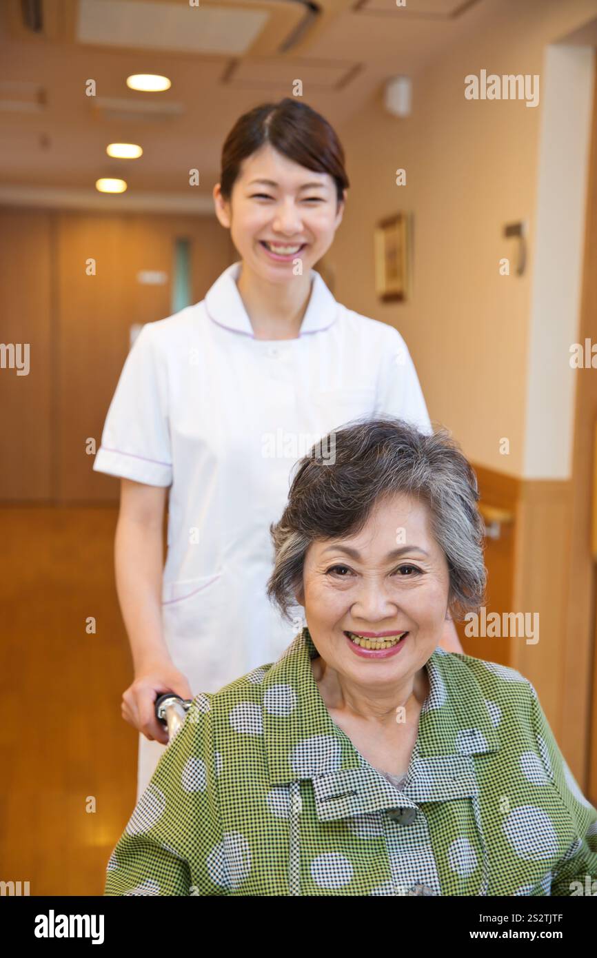 Nurse pushing a wheelchair for a senior female patient Stock Photo - Alamy