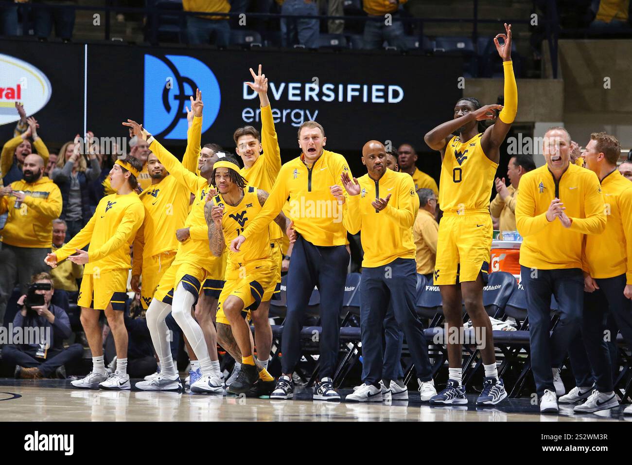 The West Virginia bench reacts during the second half of an NCAA