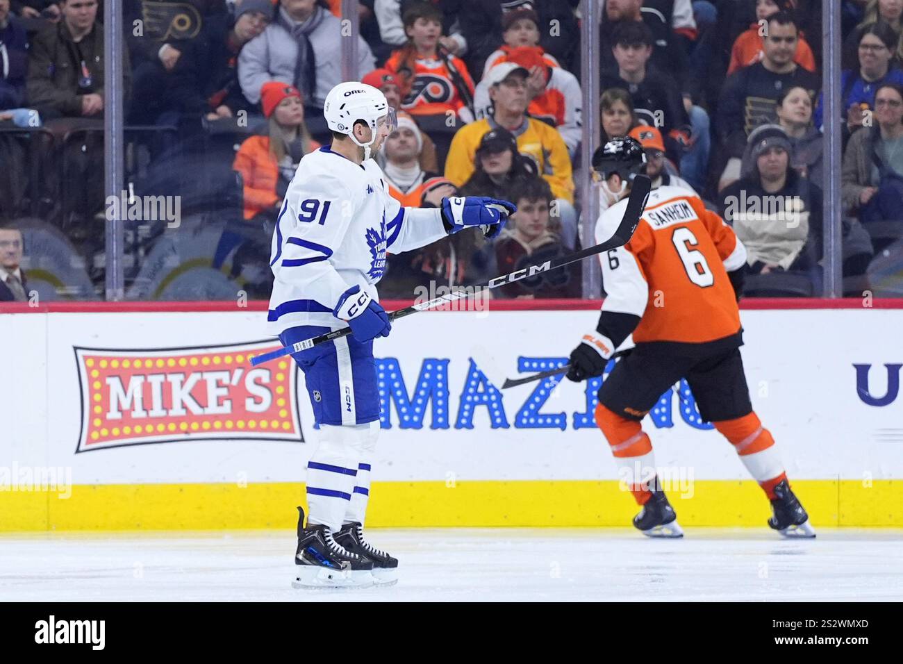 Toronto Maple Leafs' John Tavares, left, reacts past Philadelphia