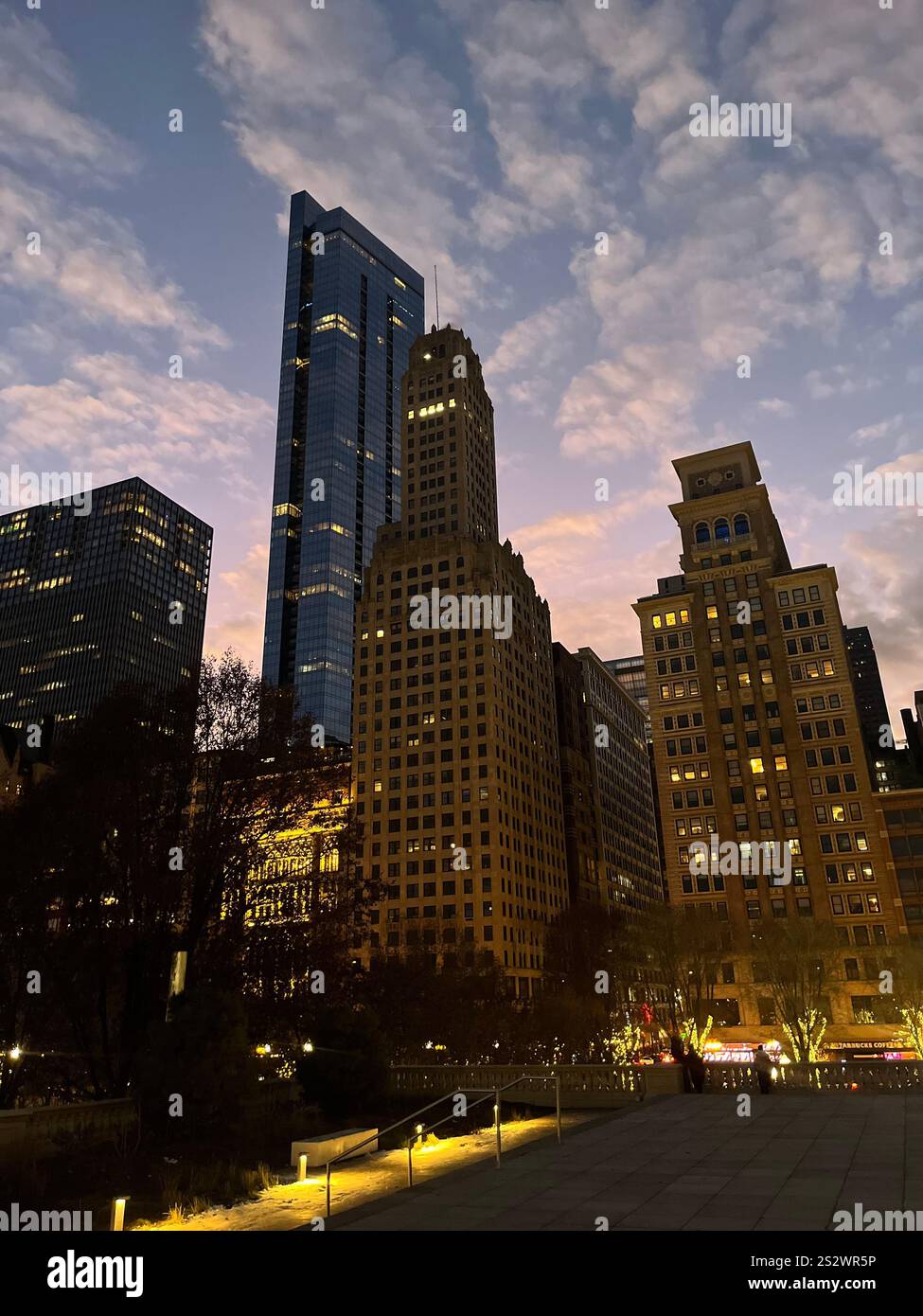 A stunning cityscape captured at dusk, featuring towering skyscrapers and historic buildings against a backdrop of a vibrant, cloud-streaked sky. - Smartphone Captured Stock Image
