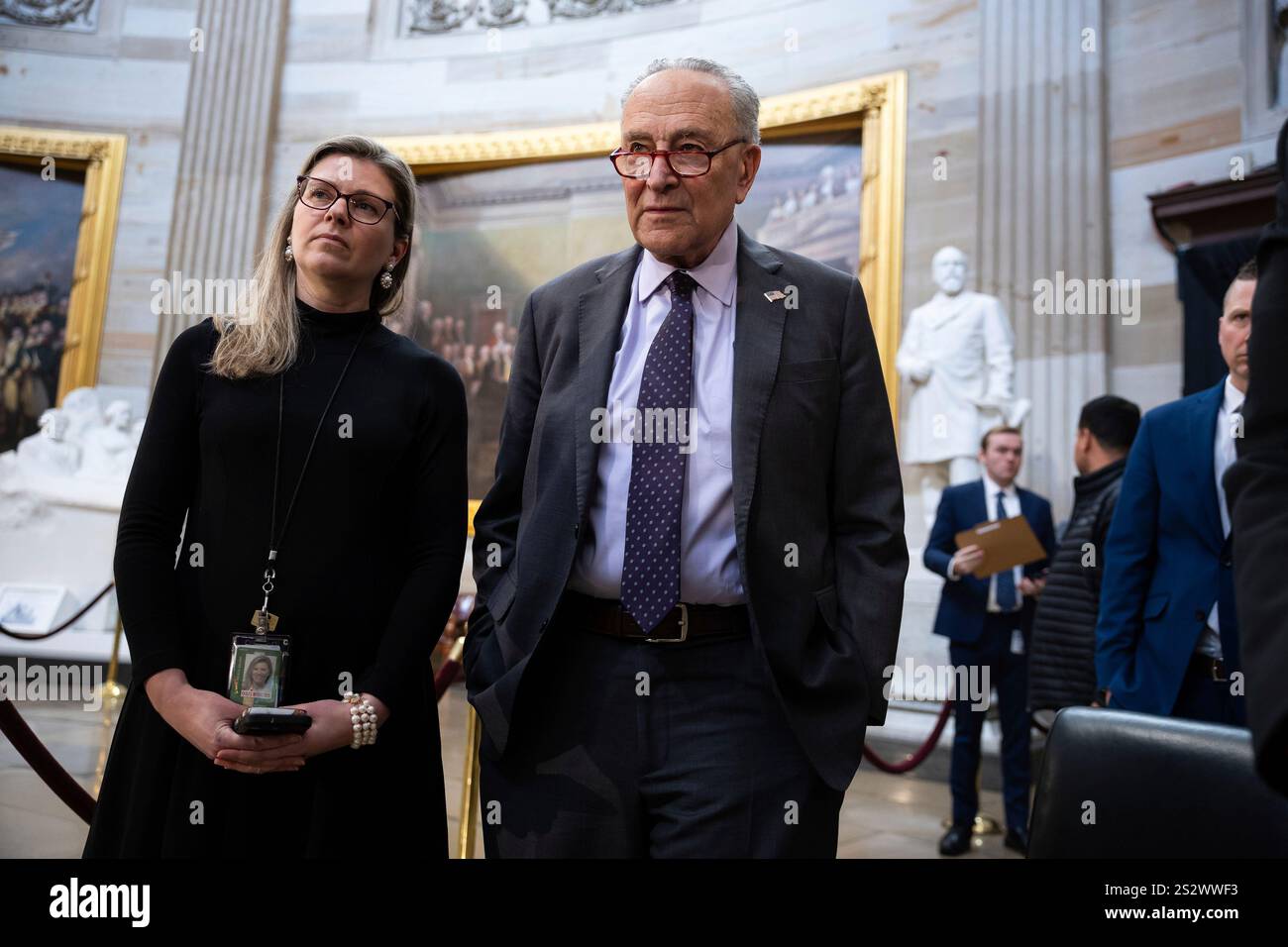 Senate Minority Leader Chuck Schumer (D-N.Y.) stands with an aide ...