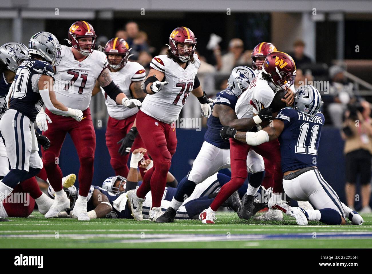 Washington Commanders quarterback Jayden Daniels (5) is tackled by ...