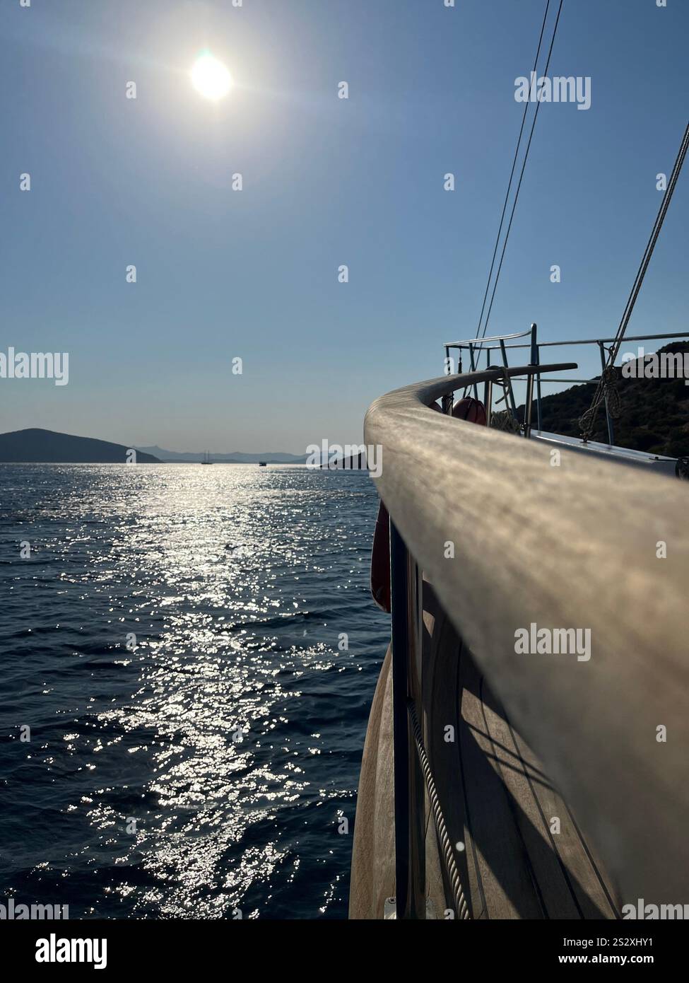 A beautiful vertical shot of yacht on the sea with mountains in the background. Amazing yacht ride in Bodrum, Turkey. - Smartphone Captured Stock Image