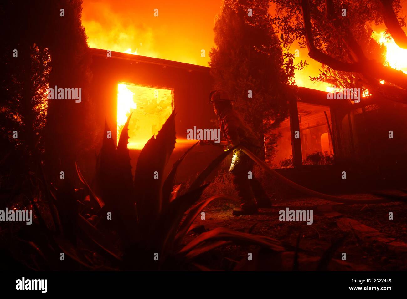 A firefighter battles the Palisades Fire in the Pacific Palisades