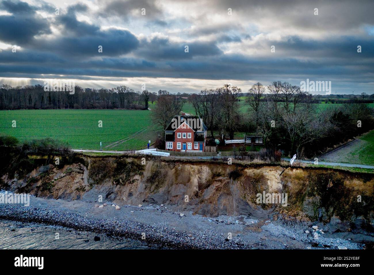 An abandoned house stands near the eroding bank of Brodten near