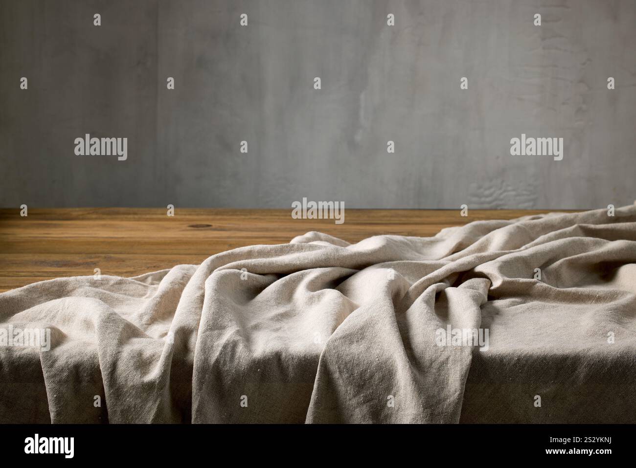 empty rustic wooden table and linen tablecloth on a gray wall background Stock Photo