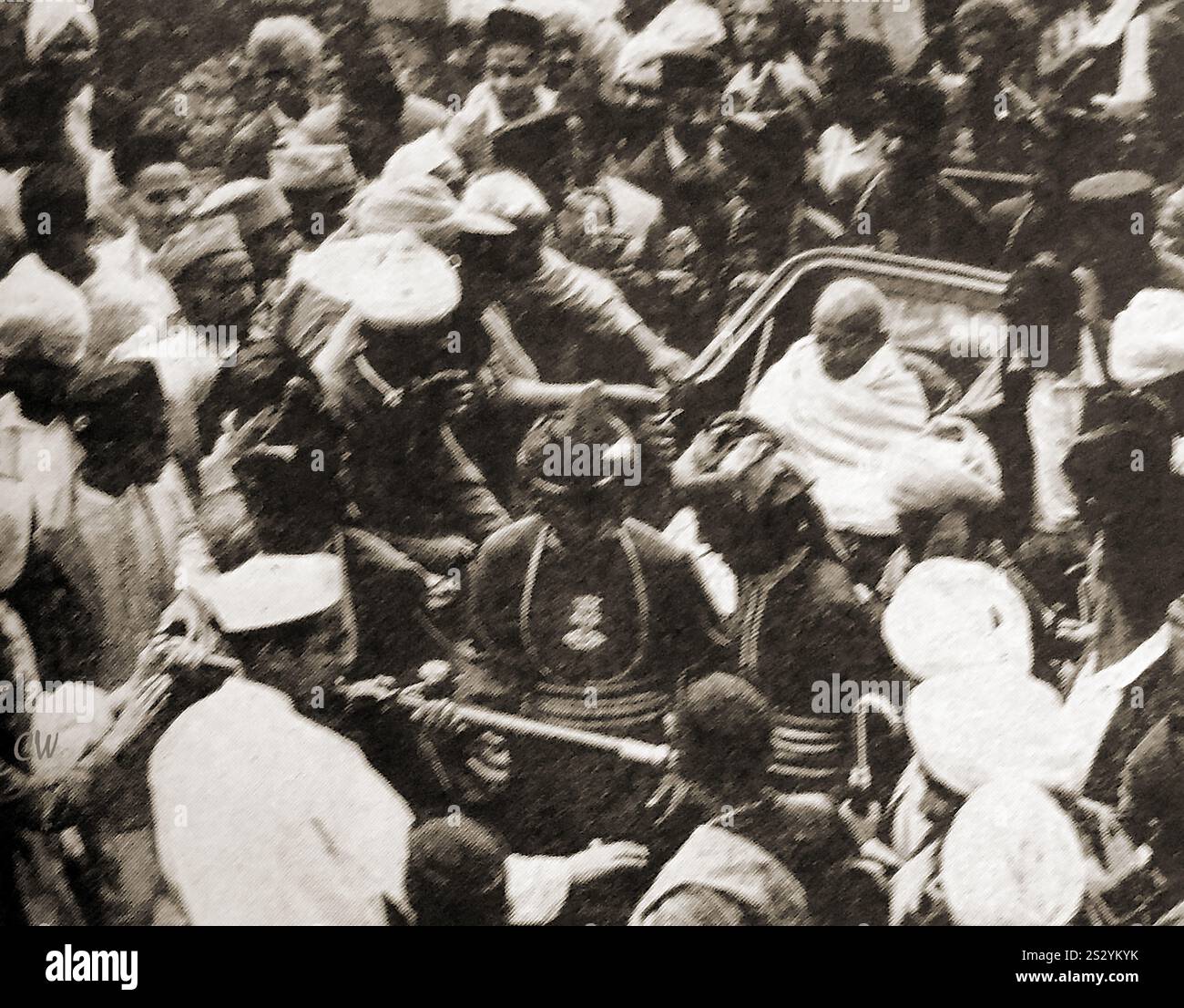 A  photograph showing Mahatma Ghandi  (Mohandas Karamchand Gandhi 1869 –  1948) being drawn through a crowded street in a hand pulled carriage. He  was an Indian lawyer, civil rights activist, anti-colonial nationalist, and political ethicist,  who  was famous for his nonviolent resistance in his  successful campaign for India's independence from British rule. Stock Photo