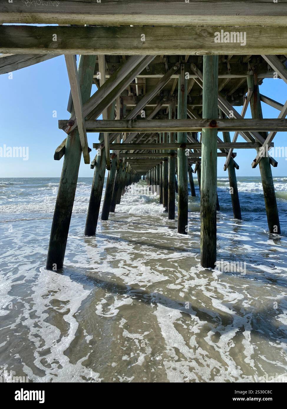A wooden pier extending into the ocean - Smartphone Captured Stock Image