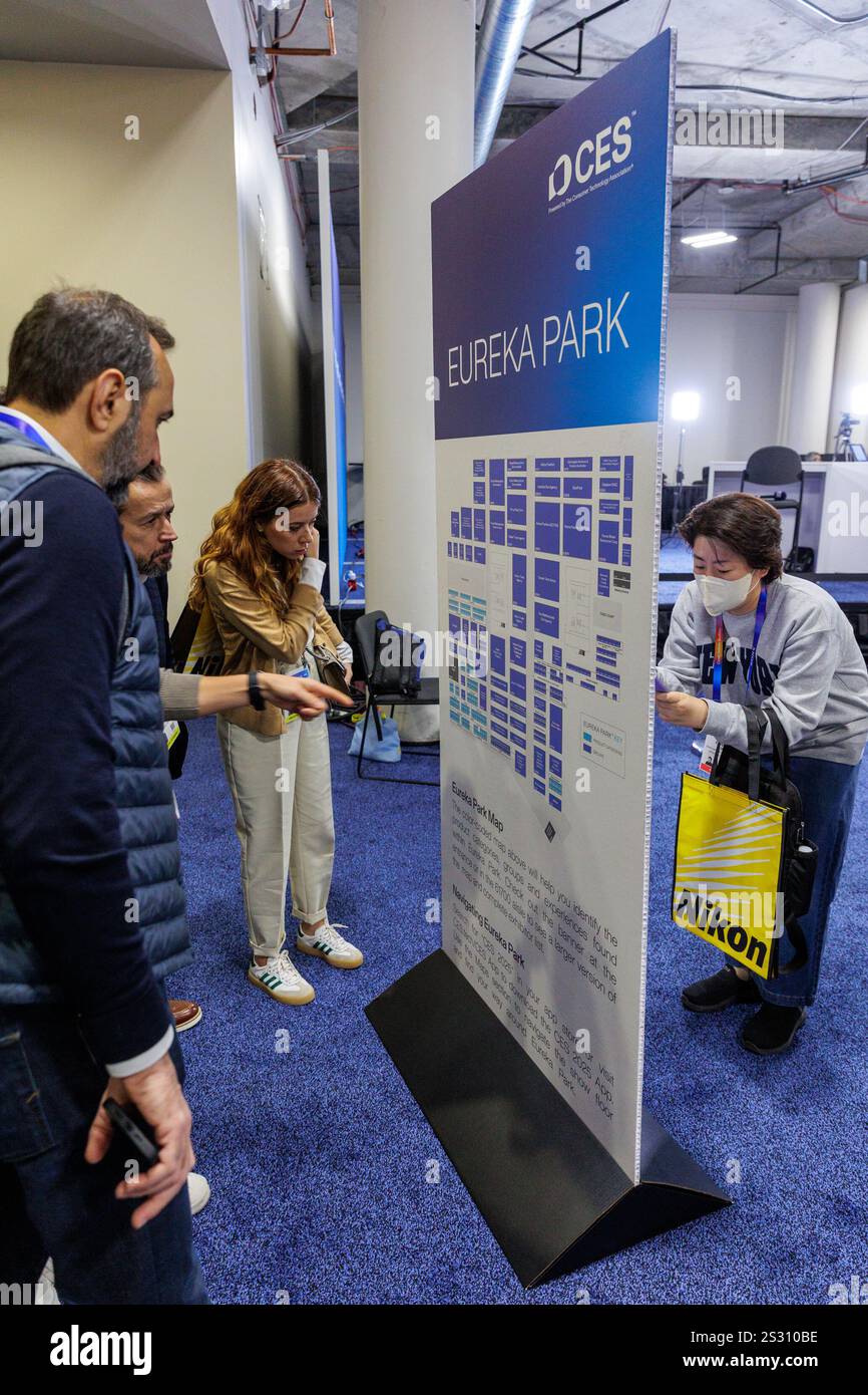 Attendees explore the map of Eureka Park on the CES 2025 show floor at the Resort in