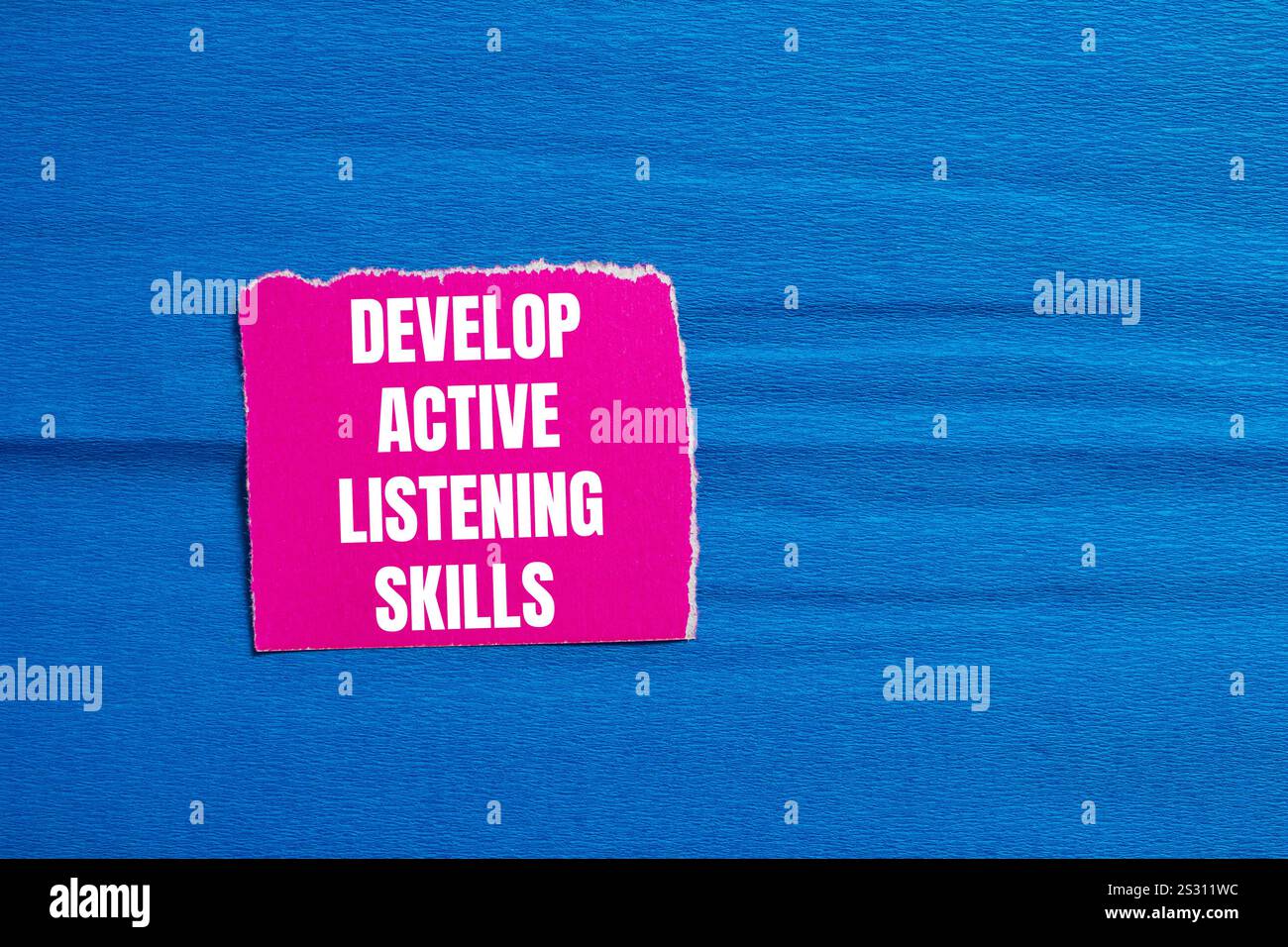 Develop active listening skills message written on ripped pink torn ...