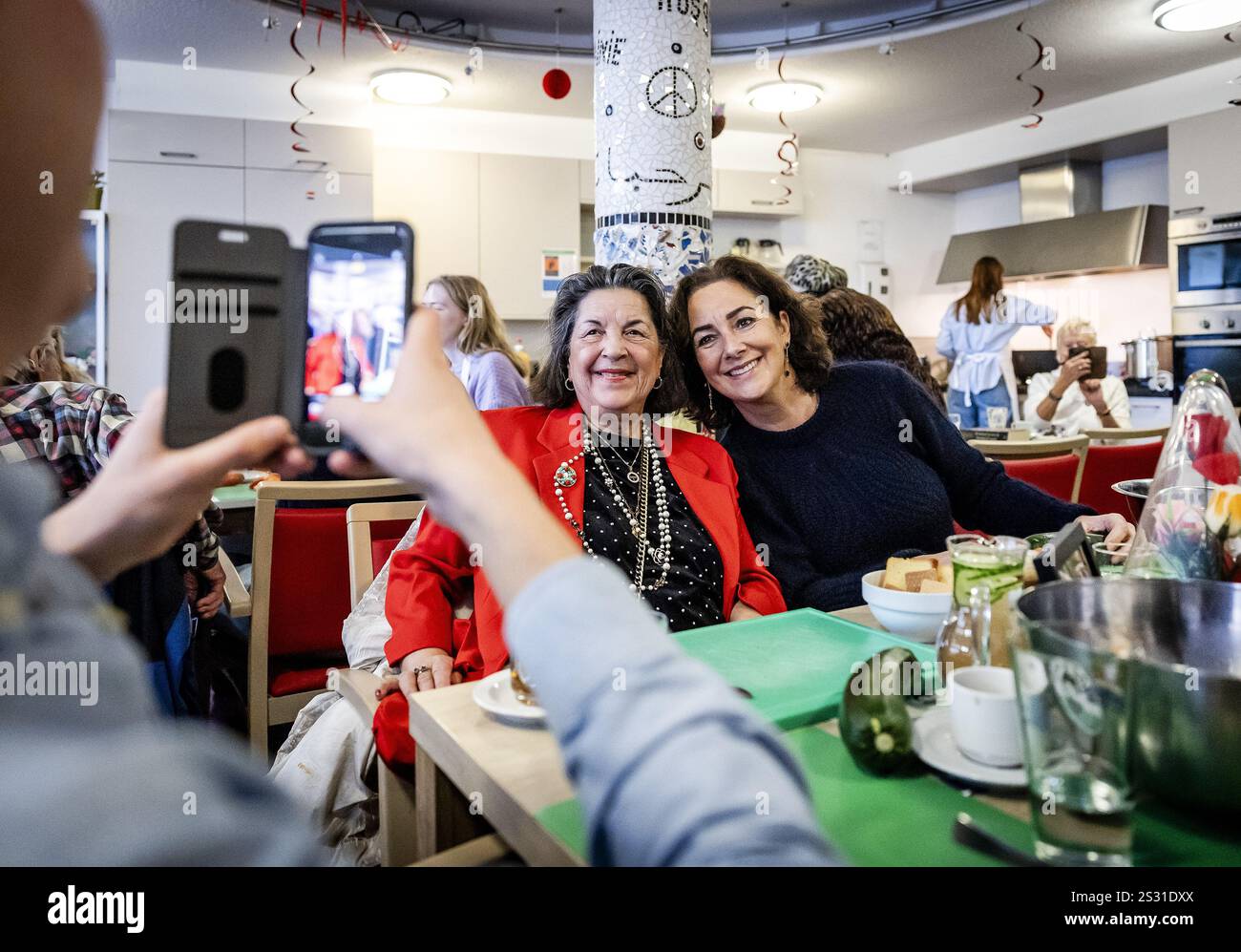 AMSTERDAM - Mayor Femke Halsema visiting a cooking day organized by the Grandma's Soup against Loneliness Foundation. The initiative, which brings together young volunteers and elderly people on a weekly basis, plays an important role in the fight against loneliness among the elderly. ANP REMKO DE WAAL netherlands out - belgium out Stock Photo