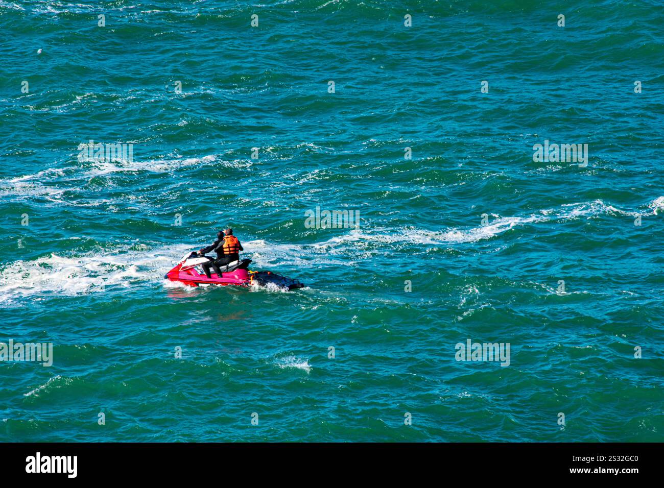 Nazaré, Portugal - A jet ski zips through the vibrant blue waters, capturing the energy of this Atlantic gem. Stock Photo